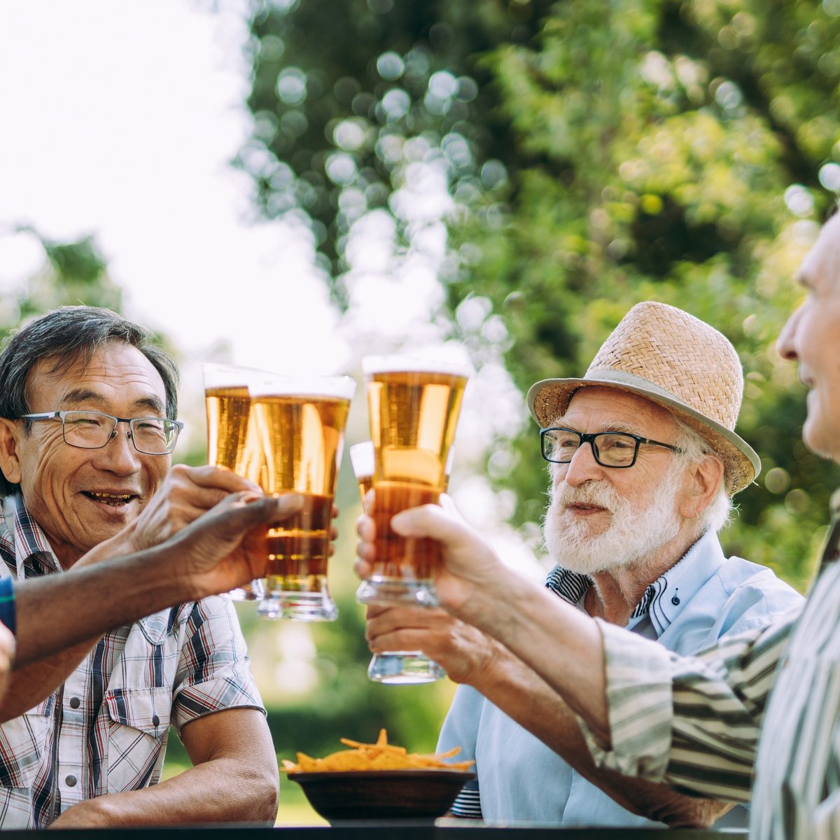 Friends raising glasses of beer at an outdoor table